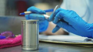 Production control supervisor inspects the can in the production line of a canned fish factory photo