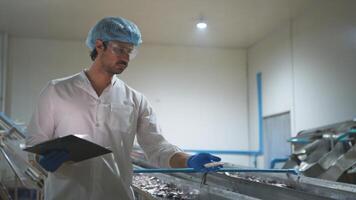 Raw material quality inspectors evaluate and inspect fish pieces before they enter the canned fish production process photo