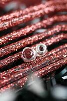 plata pendientes con redondo rojo piedras preciosas en rojo Brillantina Navidad antecedentes. hecho a mano joyas. foto