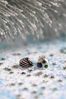 hecho a mano elegante plata pendientes con piedras preciosas en blanco Navidad Brillantina antecedentes. foto