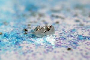 elegante plata en forma de corazon pendientes en Brillantina antecedentes Perfecto para san valentin día. foto