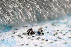 hecho a mano elegante plata pendientes con piedras preciosas en blanco Navidad Brillantina antecedentes. foto