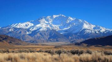 A mountain range with a snow capped peak photo