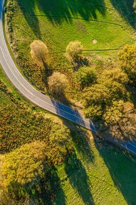 directly above aerial drone view of a mountain road curve in spring