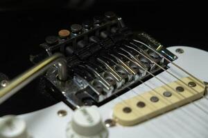 detail of the bridge of an electric guitar, strings and control photo