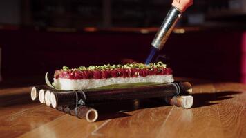 Close up of professional chef using butane torch to sear and heat sushi video