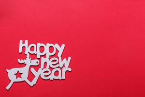 beautiful branches of a Christmas tree with cones and toys on a red background with the inscription Happy New Year photo