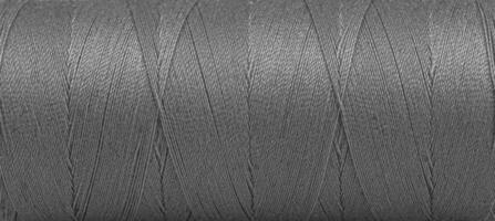 Texture of threads in a spool of grey color on a white background photo