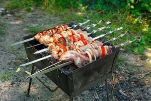 Cooking barbecue with vegetables on skewers. Roasted meat on the grill photo