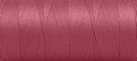 Texture of threads in a spool of red color on a white background photo