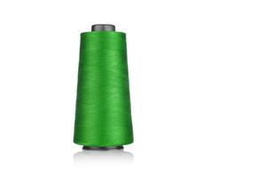 spool of industrial thread green color, texture of thread on a white background photo