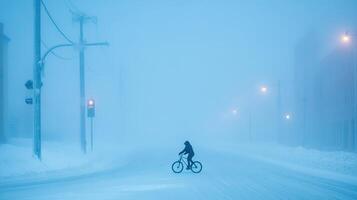 Cyclist in snowy urban street amid heavy fog and illuminated streetlights. photo