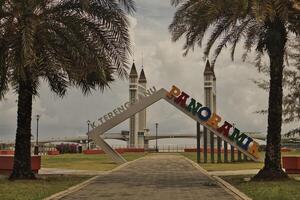 A stunning photogenic Kuala Terengganu drawbridge under a dramatic cloudy sky with structure featuring twin towers and a modern design that nestled against the ocean below. photo