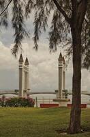 A stunning photogenic Kuala Terengganu drawbridge under a dramatic cloudy sky with structure featuring twin towers and a modern design that nestled against the ocean below. photo