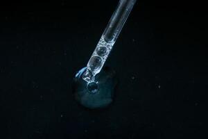 Pipette drop on black background photo