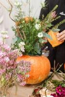 Creating a floral composition in a pumpkin. Making decor with your own hands. photo