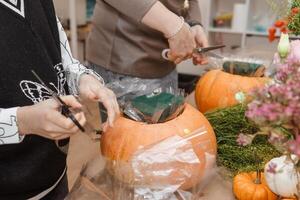 Creating a floral composition in a pumpkin. Making decor with your own hands. photo