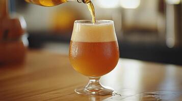 Craft beer being poured into a clear glass on a wooden table photo