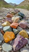 Colorful collection of smooth stones arranged on a natural surface in bright sunlight photo