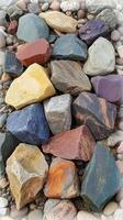 Colorful collection of smooth stones arranged on a natural surface in bright sunlight photo