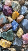 Colorful collection of smooth stones arranged on a natural surface in bright sunlight photo