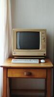 Vintage computer setup with monitor and keyboard on a wooden desk photo