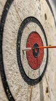 Dart with heart-shaped tip hitting the center of target in a serene blue water background photo