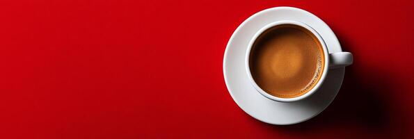 Freshly brewed coffee in a white cup on a vibrant red table photo