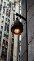 Vintage street lamp illuminates urban building facade during evening hours photo