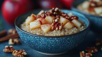 Warm apple and pecan quinoa bowl served with cinnamon and nutmeg for breakfast or snack photo