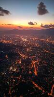 View of city skyline illuminated at sunset with mountains in the background photo