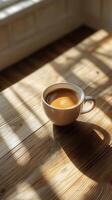 Warm coffee cup resting on wooden table by the window in cozy cafe setting photo