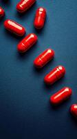 Red capsules scattered on a vibrant blue surface highlighting texture and detail photo