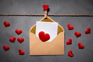 clothespins with red hearts on a rope on a gray background. Background for a postcard photo