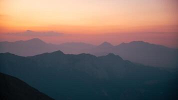 Silhouettes of mountains in a beautiful gentle haze, mountains at sunset or sunrise, natural background photo
