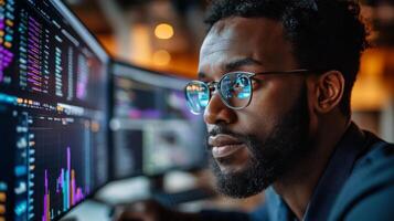 Young professional analyzing data on multiple computer screens in a modern office setting photo
