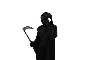 Grim reaper in Halloween costume holding scythe and making phone call with cellphone white background photo