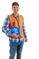vertical Construction worker smiling at camera while holding safety helmet under arm photo