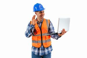 Engineer making a call with laptop wearing reflective orange vest and safety helmet photo