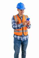 vertical Smiling construction worker texting on his smartphone wearing orange vest and safety helmet photo