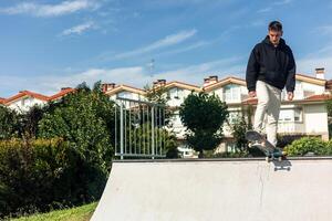 copyspace Concentrated skater on skateboard at edge of half-pipe ready to drop photo