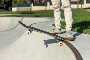 copyspace Close-up of a skater's legs with skateboard parallel at the edge of the skate park bowl photo