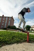 vertical unrecognized Skater executing a grind on a rail captured from a fish-eye view photo