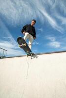 vertical Fish-eye view of a focused skater on the edge of the half pipe photo