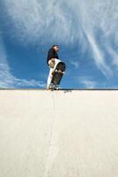 copyspace vertical Fish-eye view of a skater standing on the edge of the half pipe photo