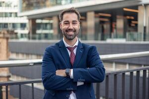 Portrait of smiling businessman with folded arms in urban setting photo