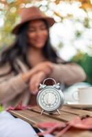 Egg timer on a wooden table with blurred latin woman in autumn background photo