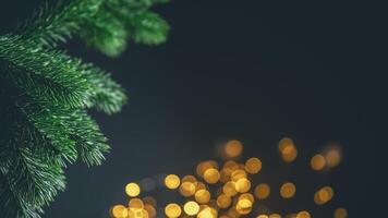 Christmas tree branch framing golden bokeh lights on a dark background creates a festive and magical holiday atmosphere, perfect for greeting cards or website banners photo