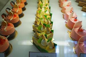 Close up Vanilla, Cassis and Uganda chocolate Eclair displayed in glass showcase bakery box photo