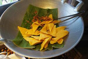 Close up deep fried Wonton, plain eggroll wrappers on green banana leaf photo